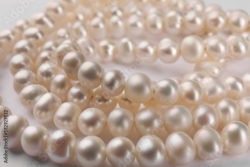 Elegant pearl necklace on white background, closeup