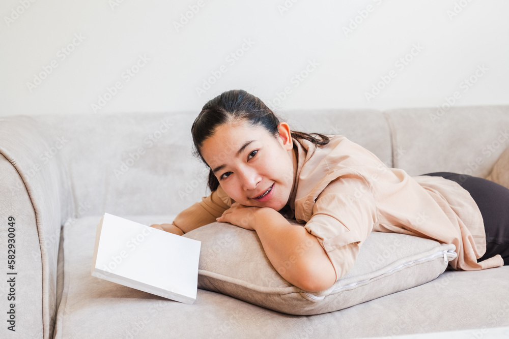Happy young Asian woman work from home working and relax on a laptop ,Book ,Cell phone social network Happy young Asian woman work from home working and relax on a laptop ,Book ,Cell phone social network