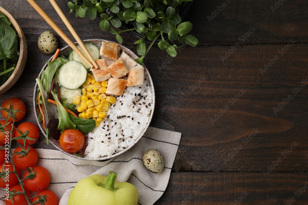 Delicious poke bowl and ingredients on wooden table, flat lay. Space for text