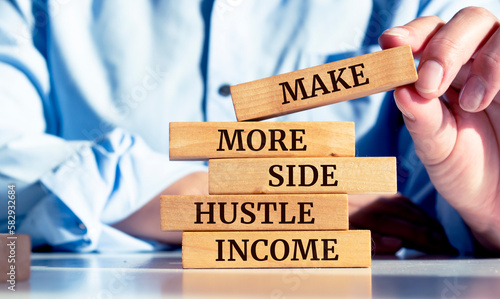 Foto Close up on businessman holding a wooden block with Make more side hustle incom