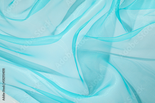 Beautiful turquoise tulle fabric as background, closeup