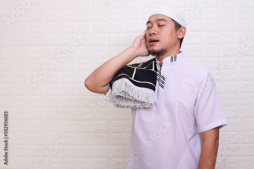 Religious Muslim man doing the call to prayer or iqamah isolated over white background photo