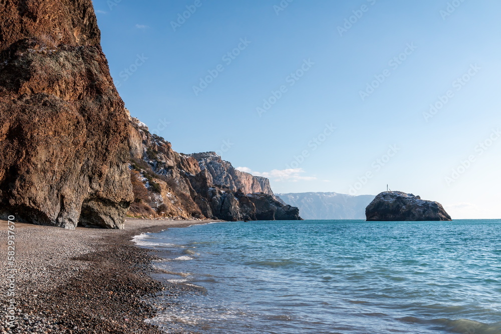 calm azure sea and volcanic rocky shores. Small waves on water surface in motion blur. Nature summer ocean sea beach background. Nobody. Holiday, vacation and travel concept