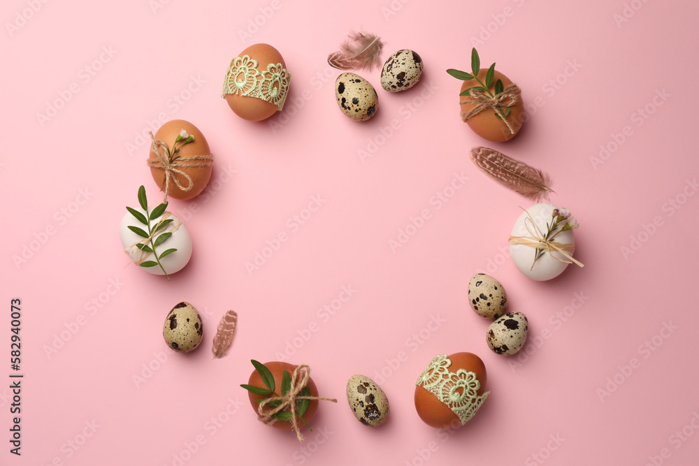 Frame made of festively decorated eggs and natural decor on pink background, top view with space for text. Happy Easter Frame made of festively decorated eggs and natural decor on pink background, top view with space for text. Happy Easter