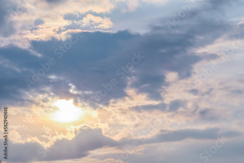 Cloudy sky background with sunlight through clouds