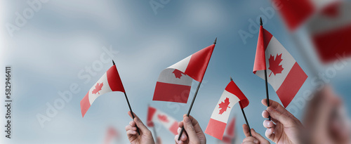 Foto A group of people holding small flags of the Canada in their hands