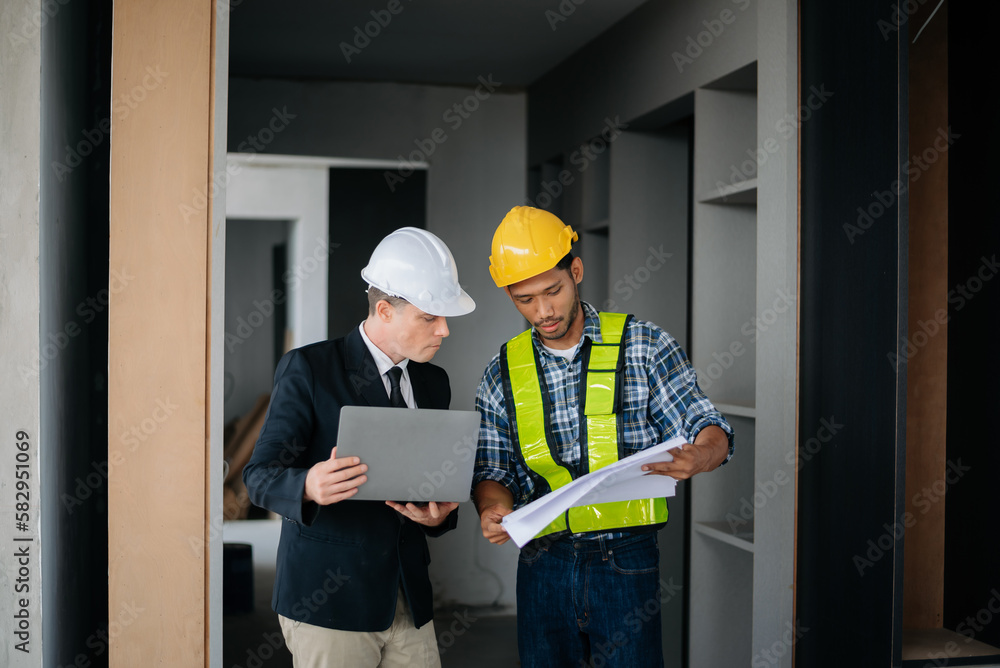 Architect caucasian man working with colleagues mixed race in the construction site. Architecture engineering on big project. Building in construction interior.. Architect caucasian man working with colleagues mixed race in the construction site. Architecture engineering on big project. Building in construction interior..