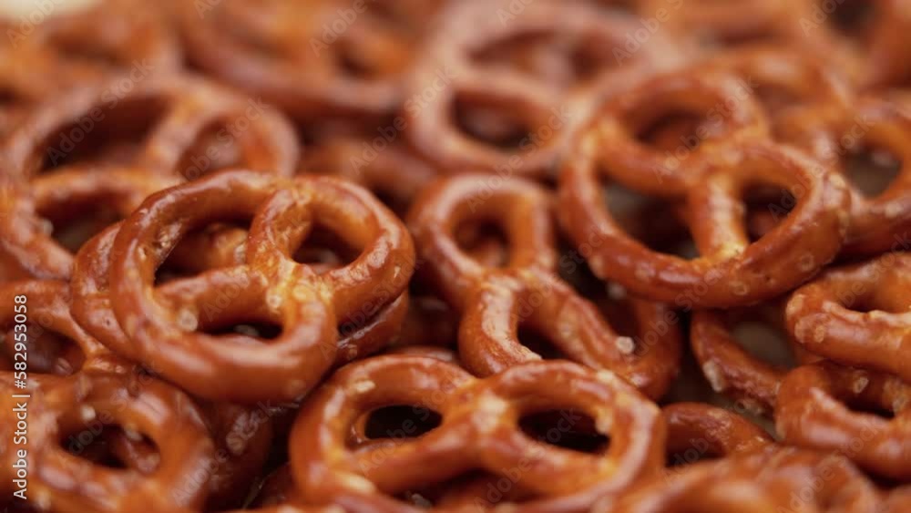 Salted pretzel crackers falling into a heap. Traditional beer snack close up. Rotation. Slow motion Salted pretzel crackers falling into a heap. Traditional beer snack close up. Rotation. Slow motion