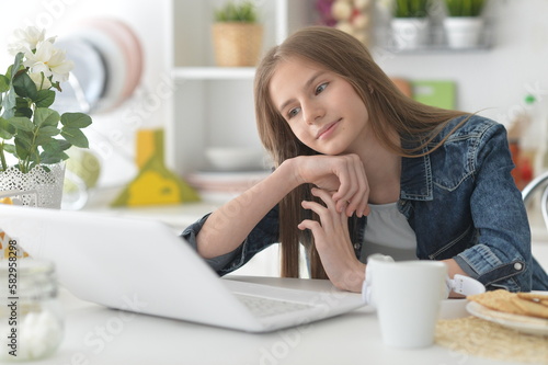 cute girl with laptop at home at desk