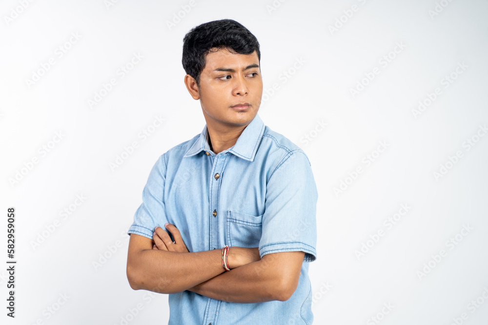 portrait of young asian man stand with crossed hands on isolated background portrait of young asian man stand with crossed hands on isolated background