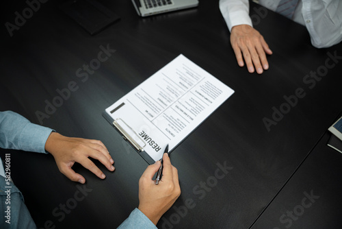 Examiner reading a resume during job interview at office Business and human resources concept.