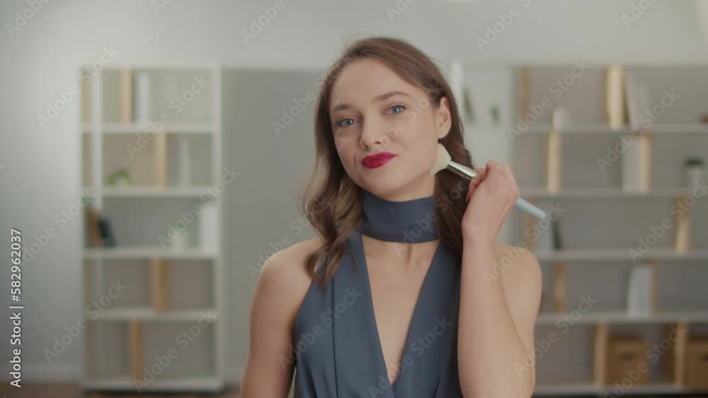 Portrait Of An Attractive Woman With Red Lips Finished Her Makeup With A Brash. Confident Young Woman in a Dress Getting Ready for an Event.Models and Fashion Trends. Portrait Of An Attractive Woman With Red Lips Finished Her Makeup With A Brash. Confident Young Woman in a Dress Getting Ready for an Event.Models and Fashion Trends.