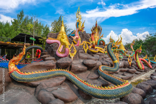 The 9 Serpent clan statue around the mountain with the Buddha statue on the top at Wat Don Khanak, Nakhon Pathom, Thailand photo