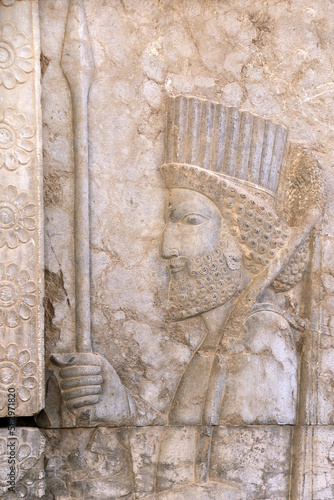 Ancient wall with bas-relief with assyrian warrior with spear, Persepolis, Iran