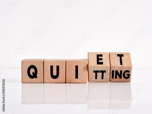 The word quiet quitting on wooden cubes. Business employment concept.