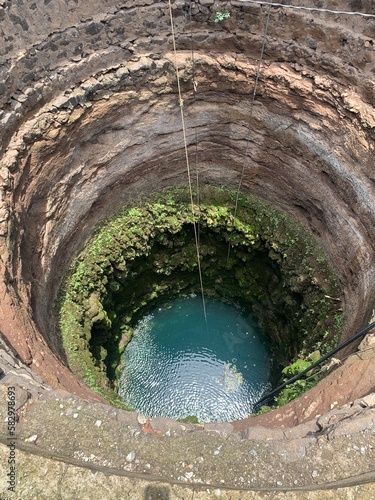 A deep well with water at the bottom, top view