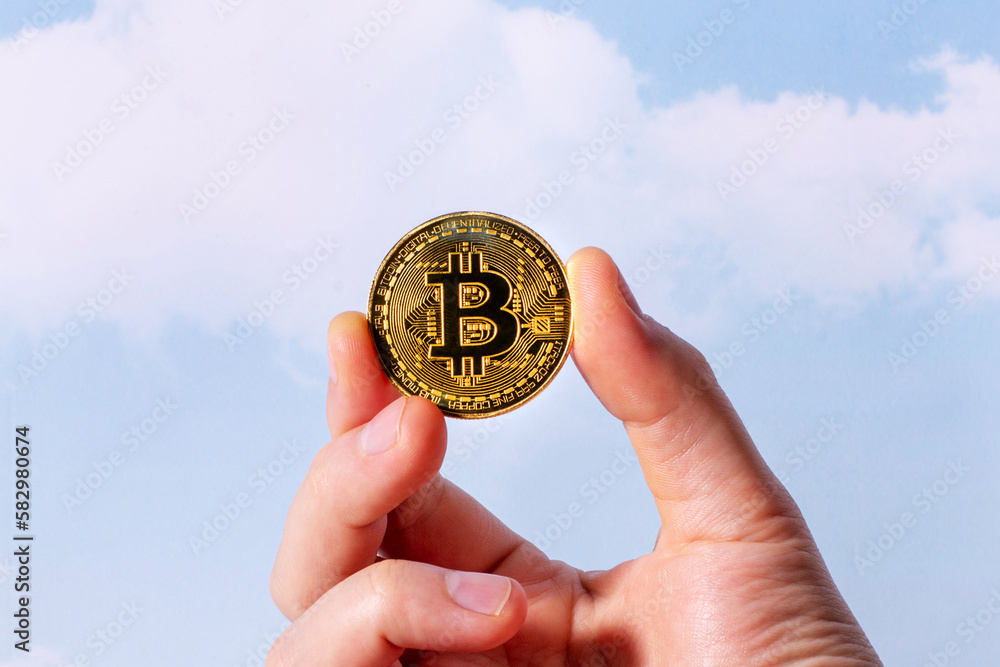 Bitcoin coin in hand on sky background.Business finance investment. Digital technology concept. Business success concept wealth stock investment. Crypto currency blockchain concept. Bitcoin coin in hand on sky background.Business finance investment. Digital technology concept. Business success concept wealth stock investment. Crypto currency blockchain concept.