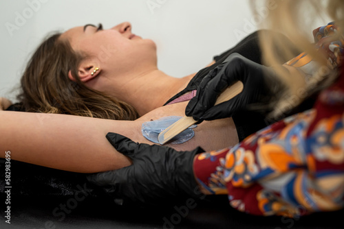 Salon wax epilation procedure by a beautician.