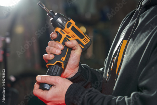 a man inserts a replacement battery into an electric wrench