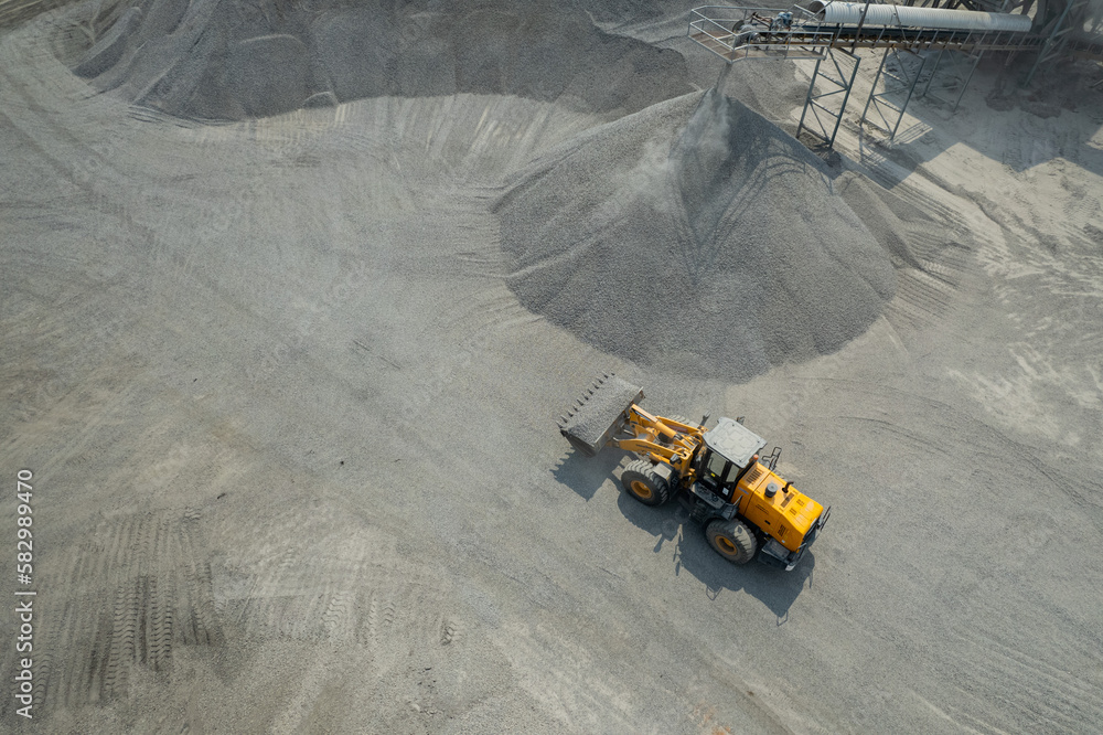 Sand loaders are shoveling rocks into dump trucks. Sand loaders are shoveling rocks into dump trucks.