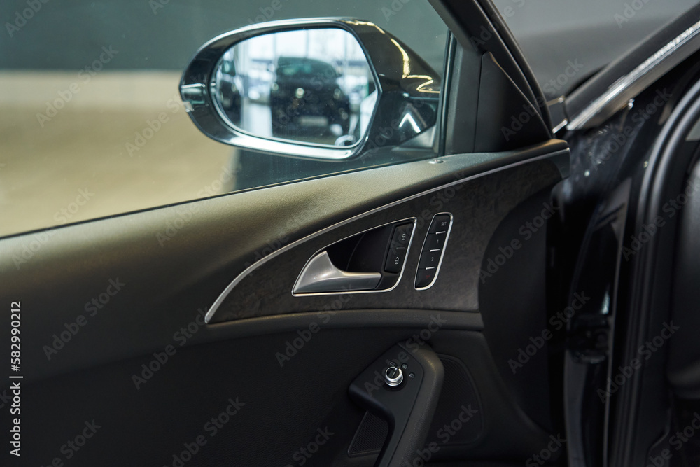 the inside of the car door with adjustable position of the outside rear-view mirror. opening handle, door lock and settings buttons