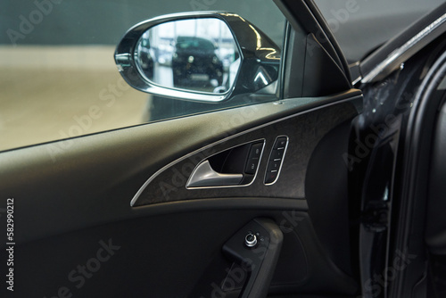 the inside of the car door with adjustable position of the outside rear-view mirror. opening handle, door lock and settings buttons © Elena