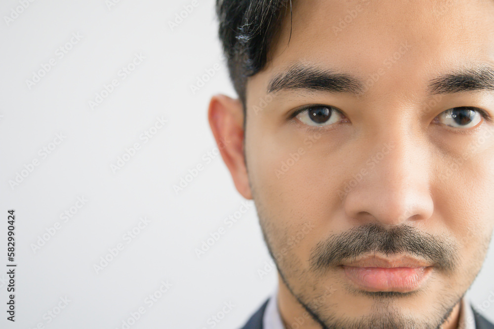Portrait of a handsome Asian man with a beard in a gray shirt with suit making a straight face.