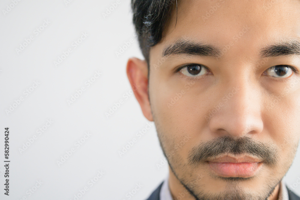 Obraz premium Portrait of a handsome Asian man with a beard in a gray shirt with suit making a straight face.