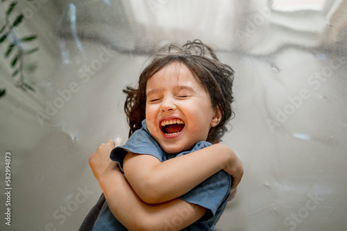 Cheerful cute boy lying on mirror photo