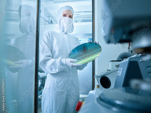 Scientist holding wafer chip standing in laboratory