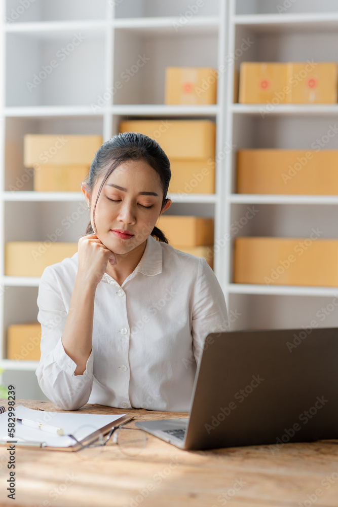 Online shopping, beautiful smiling asian woman checking order and customer details and address on laptop or box to prepare delivery accordingly, SME online shopping Online shopping, beautiful smiling asian woman checking order and customer details and address on laptop or box to prepare delivery accordingly, SME online shopping