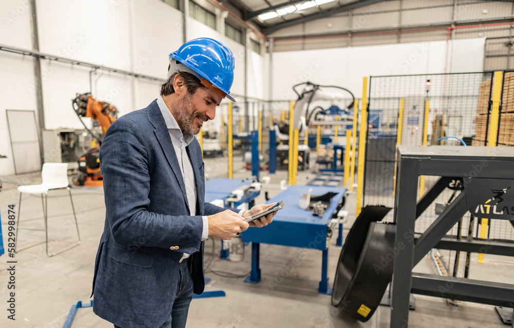 Engineer wearing hardhat using tablet PC at industry Engineer wearing hardhat using tablet PC at industry