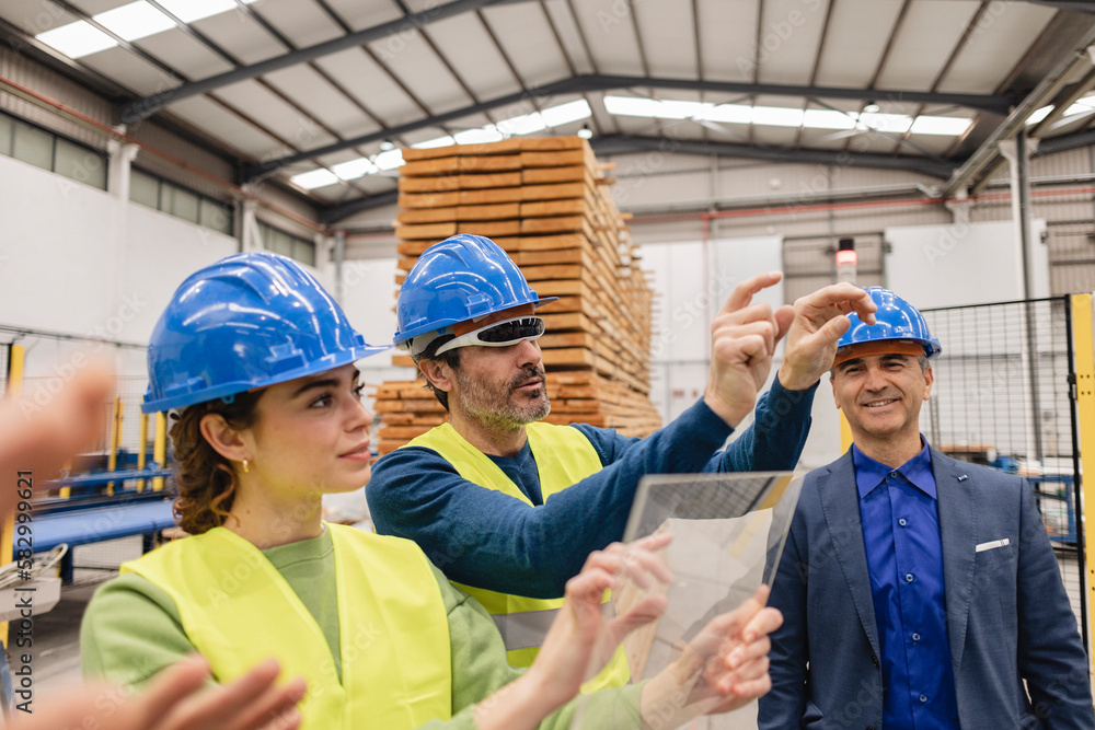 Engineer wearing smart glasses with colleagues in robotics factory Engineer wearing smart glasses with colleagues in robotics factory
