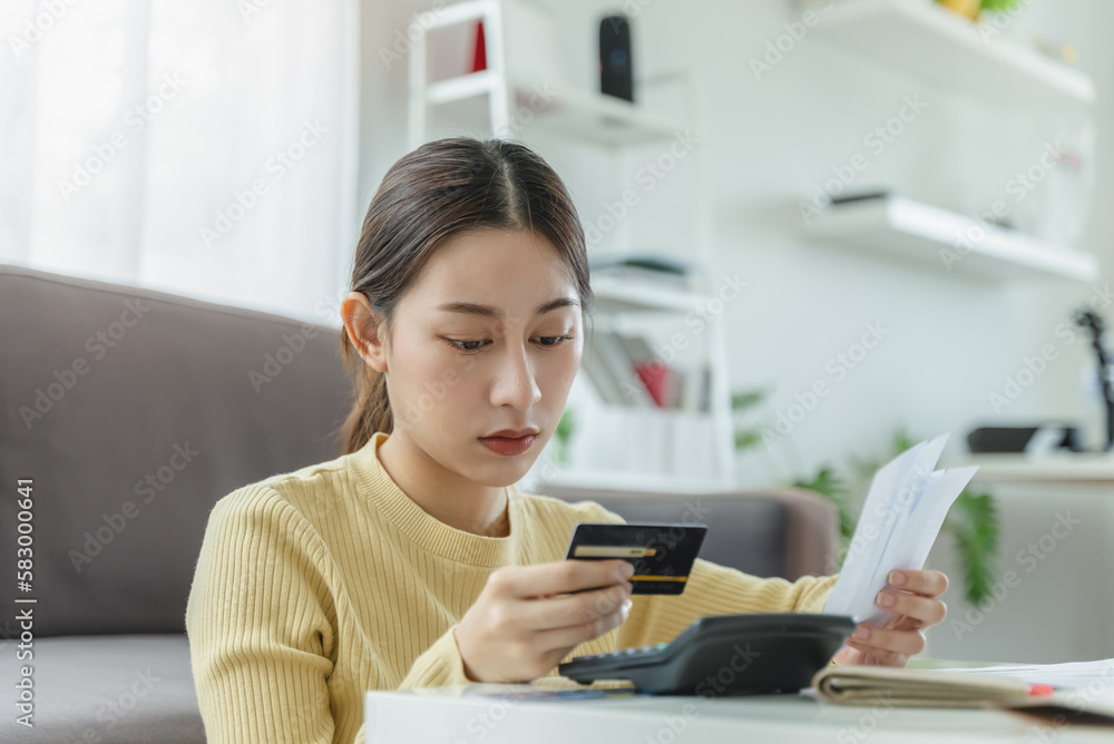 Asian woman reviewing credit card spend and planning monthly financial Asian woman reviewing credit card spend and planning monthly financial