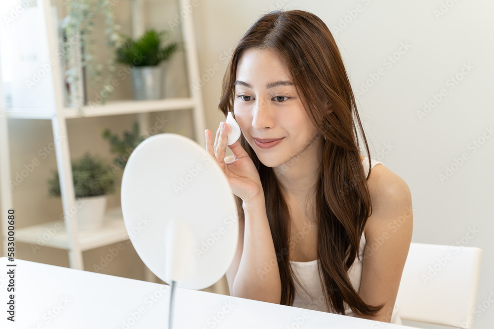 Young asian woman applying moisturizer on face after use toner cleansing remove cosmetic. Young asian woman applying moisturizer on face after use toner cleansing remove cosmetic.