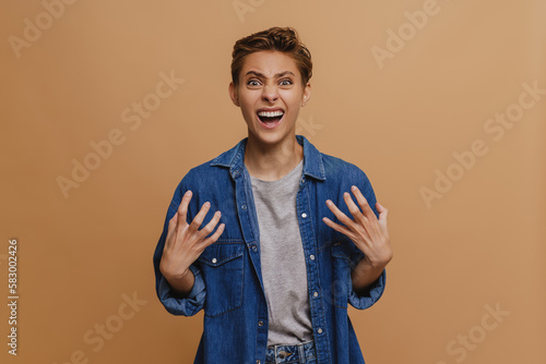 Photography Portrait of young short-haired beautiful insidious woman with opened mouth