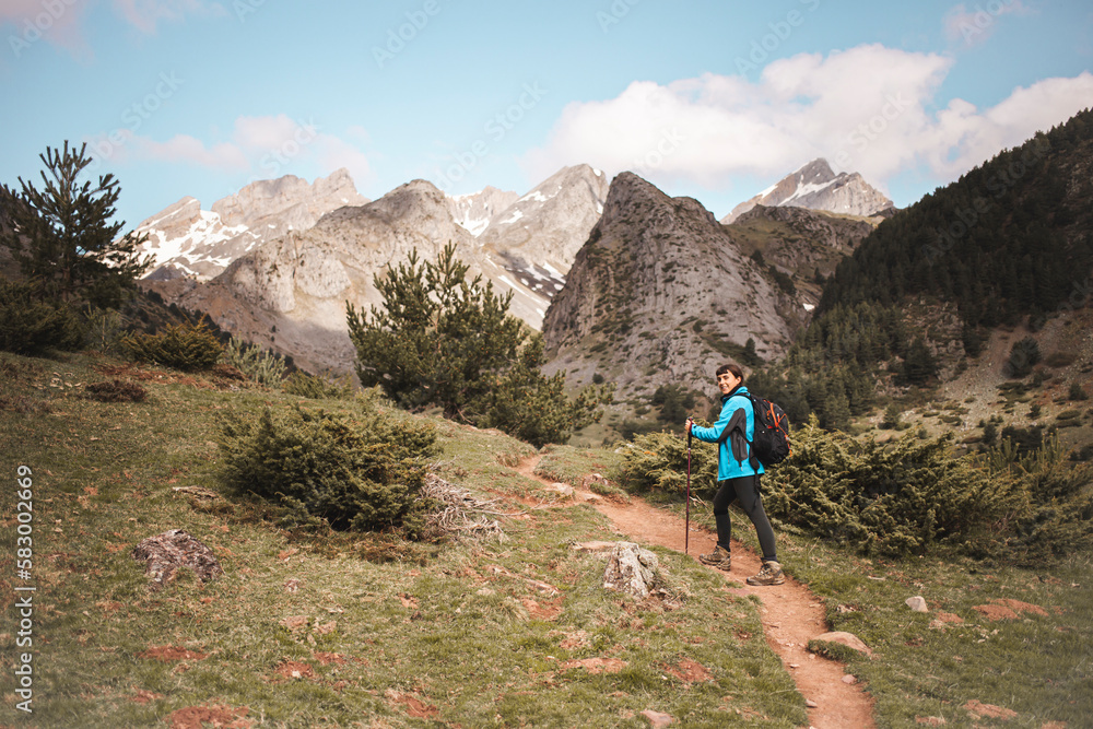 Woman trekking on footpath towards mountains Woman trekking on footpath towards mountains