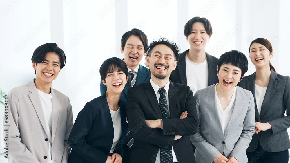 オフィスで大笑いする大勢のビジネスパーソン オフィスで大笑いする大勢のビジネスパーソン