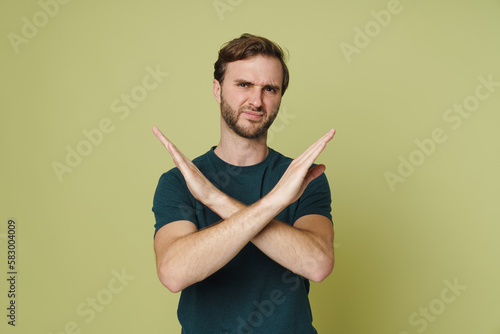 Man showing denial gesture isolated over green background