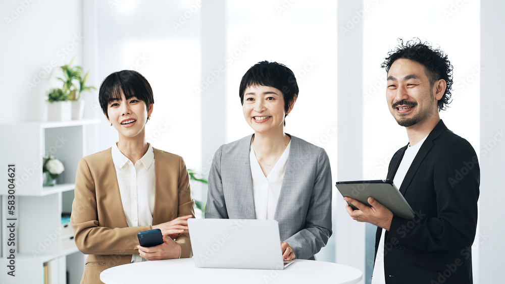 オフィスで笑うビジネスパーソンのグループ