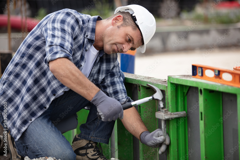 male worker adjusting clamp on site shuttering male worker adjusting clamp on site shuttering