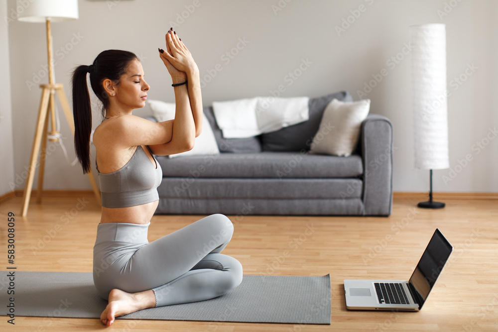 Young woman stretches at home after exercising