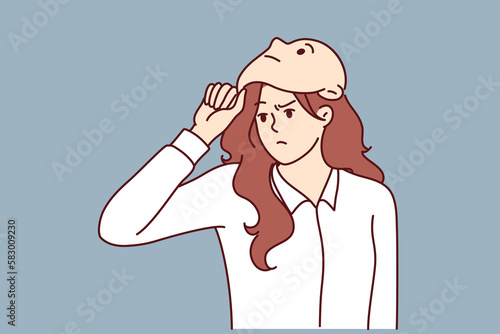 Frowning woman removes mask from face designed to hide identity or show fake emotions. Mask metaphor of lies and hypocrisy for purpose of fraud or obtaining insider information in business 