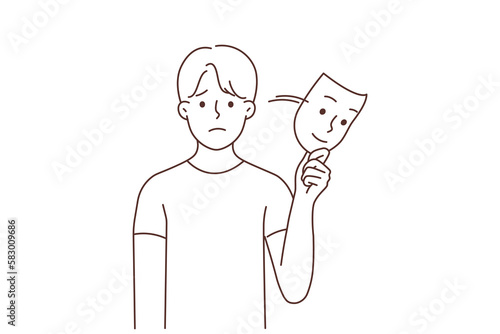 Unhappy man take off smiling mask 