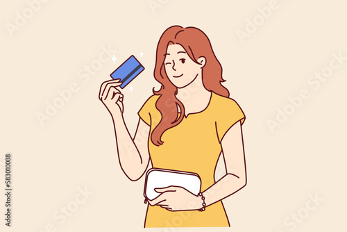 Woman with bank card winking recommend using reliable banking or credit product with large cashback. girl shows credit card intended for bargain purchases or cash withdrawals from ATM 