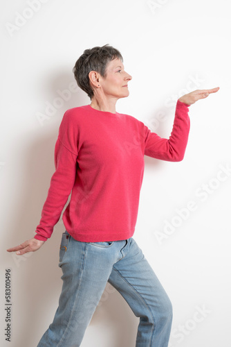 Paris, France - 03 18 2023: Studio shot of a mature woman with short hair posing and wearing a pink sweater photo