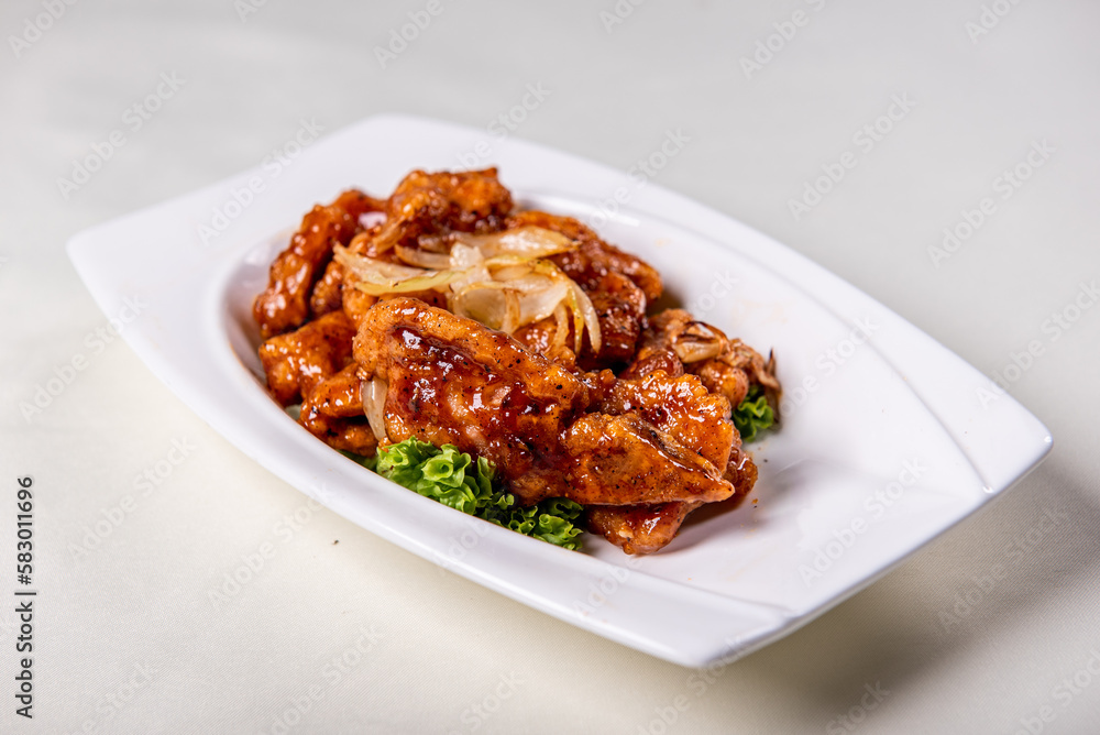 fresh wok fried sweet and sour pork chop chicken in Mongolian style on wood table background asian Chinese halal banquet meat menu for restaurant