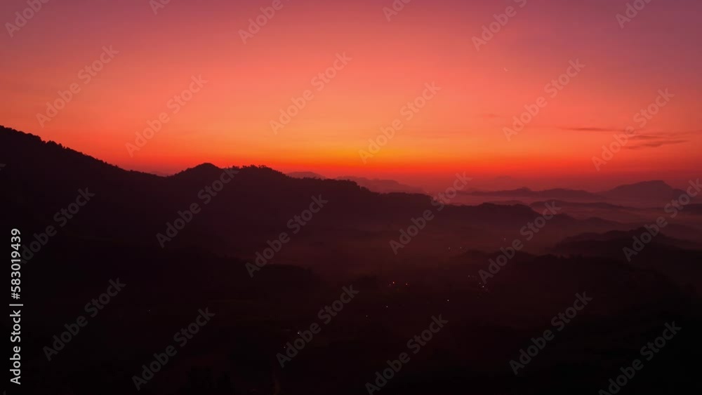 aerial view stunning sunset above the mountain ridge in twilight. .Scene of colorful red light trough in the dark sky..Gradient color. Sky texture, amazing abstract nature background. aerial view stunning sunset above the mountain ridge in twilight. .Scene of colorful red light trough in the dark sky..Gradient color. Sky texture, amazing abstract nature background.