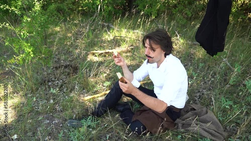 Hungarian poet Sandor Petofi resting in shady field enjoying snack. Male actor. photo