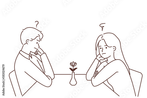 Unhappy man and woman at table in cafe